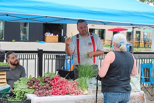 Graeme Knight of Prairie Knight Farms sells some of his produce during the opening hour of Friday’s Summer Soulstice Block Party in downtown Brandon. (Kyle Darbyson/The Brandon Sun)