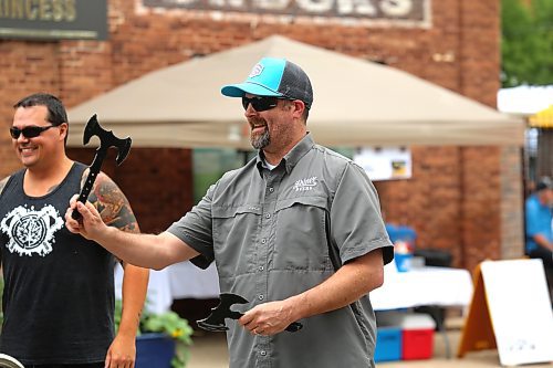 Spencer Beard gets ready to hurl an axe alongside a member of Kickin’ Axe Throwing during Friday’s Summer Soulstice Block Party on Princess Avenue. (Kyle Darbyson/The Brandon Sun)