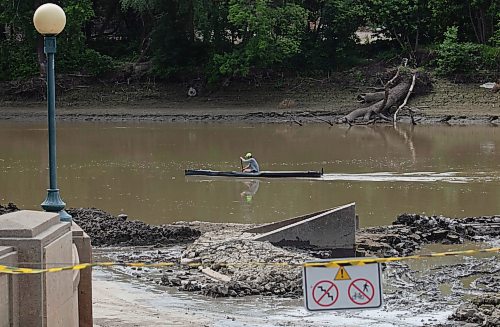 Mike Thiessen / Winnipeg Free Press 
A kayaker paddles past the cleanup of the Forks River Trail, south of the Legislative Building. 230623 &#x2013; Friday, June 23, 2023