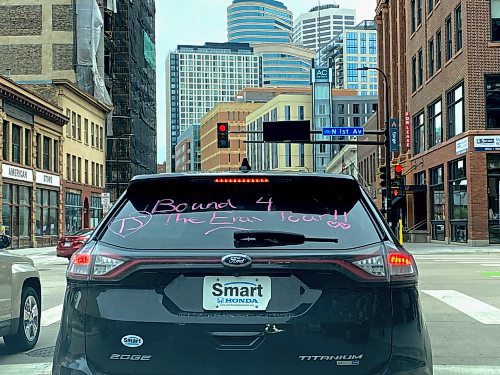 A car drives in downtown Minneapolis with paint on the back that reads "Bound for The Eras Tour." (Nadya Pankiw / Winnipeg Free Press)