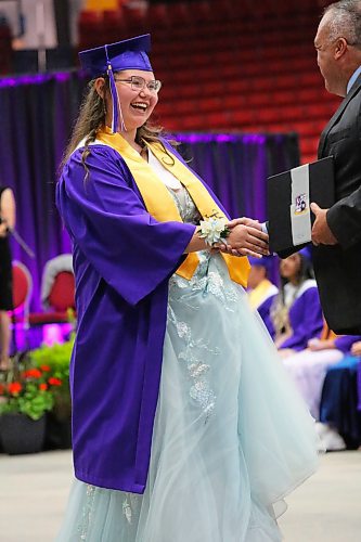 Lucy MacPherson-Blair shakes hands with Vincent Massey High School principal Bryce Ridgen as she picks up her diploma during Monday’s graduation ceremony at the Keystone Centre. (Kyle Darbyson/The Brandon Sun) 