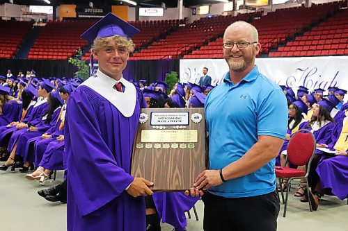 Vincent Massey High School phys ed teacher Mike Steeves congratulates Justin Sharp for being named Outstanding Male Athlete of the Year during Monday’s graduation ceremony at the Keystone Centre. (Kyle Darbyson/The Brandon Sun)