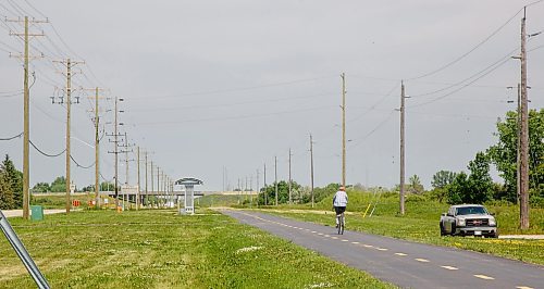 MIKE DEAL / WINNIPEG FREE PRESS
A cyclist rides north on the Northeast Pioneers Greenway which runs alongside the area where the coyote attacked a nine-year-old boy Saturday night.
230626 - Monday, June 26, 2023.