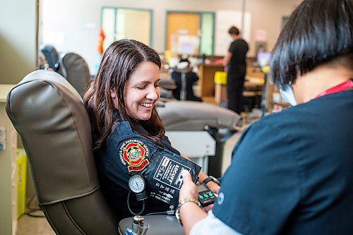 MIKAELA MACKENZIE / WINNIPEG FREE PRESS


Lanie Drysdale takes Erin Madden&#x2019;s blood as part of the Sirens for Life campaign on Tuesday, June 27, 2023. The campaign is a challenge between first responders to see which agency can bring in the most donations.
Winnipeg Free Press 2023