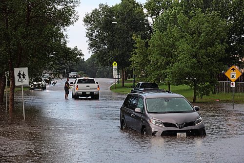 27062023
A car sits in a flooded street on East Fotheringham Drive at Regent Crescent in Brandon after heavy rains pounded Brandon on Tuesday leading to flooding throughout the city.
(Tim Smith/The Brandon Sun)