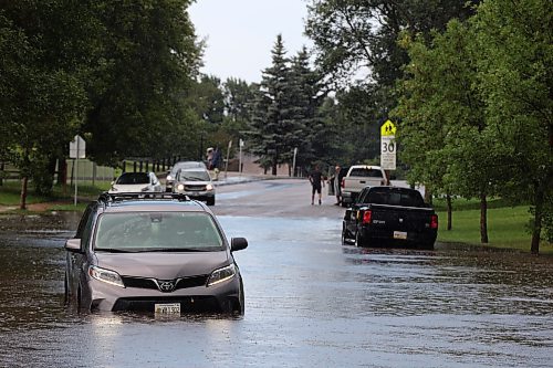 27062023
A car sits in a flooded street on East Fotheringham Drive at Regent Crescent in Brandon after heavy rains pounded Brandon on Tuesday leading to flooding throughout the city.
(Tim Smith/The Brandon Sun)