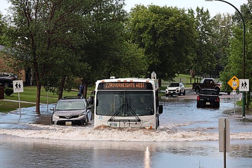 27062023
A bus passes by a stalled car in a flooded street on East Fotheringham Drive at Regent Crescent in Brandon after heavy rains pounded Brandon on Tuesday leading to flooding throughout the city.
(Tim Smith/The Brandon Sun)