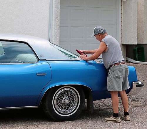  Norm Popien applies polish to his 1973 Pontiac Parisienne Brougham four-door hardtop, in Brandon on Wednesday. (Michele McDougall/The Brandon Sun).