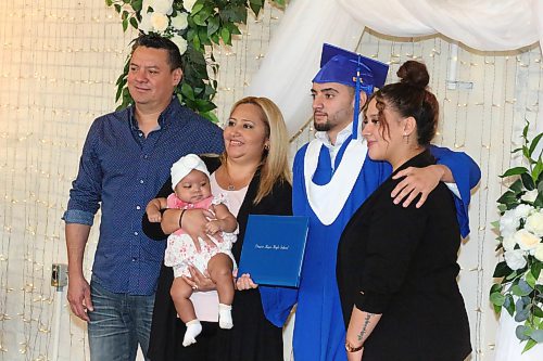Erick Mendoza Landaverde poses for a photo with his family after receiving his diploma during Prairie Hope High School’s Thursday morning graduation ceremony at The Firehall event venue. (Kyle Darbyson/The Brandon Sun) 