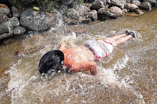 30062023
Maddy Bodz leaps into the water at the creek near the campground at Dauphin&#x2019;s Countryfest 2023 on a hot Friday afternoon.
(Tim Smith/The Brandon Sun)