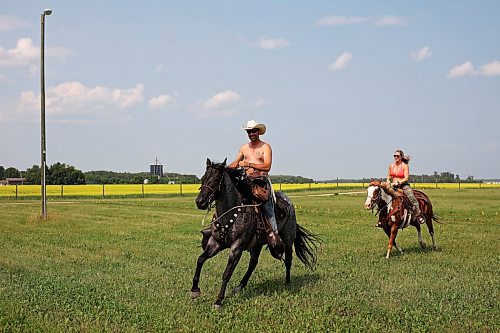 30062023
Clint Marzoff and Dayna Johnson ride horses Goose and Blaze through the campground at Dauphin&#x2019;s Countryfest 2023 on a hot Friday afternoon. Marzoff works as horse patrol for the festival.
(Tim Smith/The Brandon Sun)