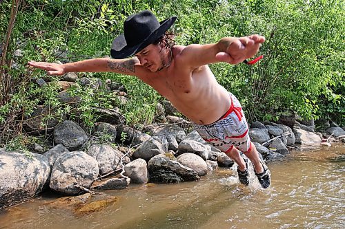 30062023
Maddy Bodz leaps into the water at the creek near the campground at Dauphin&#x2019;s Countryfest 2023 on a hot Friday afternoon.
(Tim Smith/The Brandon Sun)