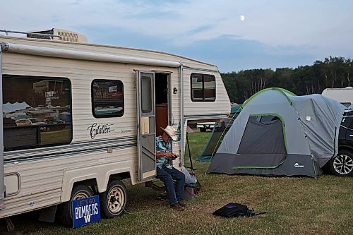 30062023
John Helgeson of Stonewall reads in the doorway of his camper as the moon rises at Dauphin&#x2019;s Countryfest 2023 on Friday evening.
(Tim Smith/The Brandon Sun)
