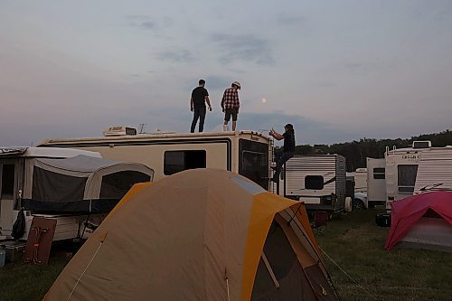 30062023
Men climb atop a camper as the moon rises at Dauphin&#x2019;s Countryfest 2023 on Friday evening.
(Tim Smith/The Brandon Sun)

