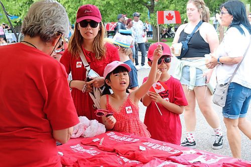 Yuexin Li buys some Canada Day souvenirs for her children Camille and Kevin at the Riverbank Discovery Centre parking lot over the long weekend. (Kyle Darbyson/The Brandon Sun) 