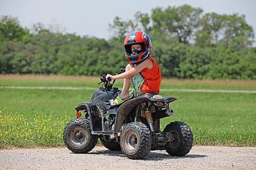 Ryatt Betts, 5, sits atop a mini quad while cruising around a family property west of Brandon on Monday. (Tim Smith/The Brandon Sun)