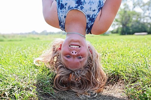 03072023
Aurora McMurachy hangs upside down while working out at the Riverbank Discovery Centre outdoor fitness equipment in Brandon on a hot Monday.
(Tim Smith/The Brandon Sun)