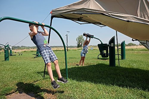 03072023
Siblings Kaizer and Aurora McMurachy work out at the Riverbank Discovery Centre outdoor fitness equipment in Brandon on a hot Monday.
(Tim Smith/The Brandon Sun)