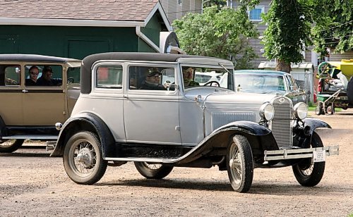 A 1931 Ford Model A two-door Victoria, owned by 93-year-old David Allinson with driver John Olver, pulls away from the Daly House Museum on Wednesday. (Michele McDougall/The Brandon Sun)