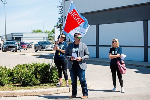 MIKAELA MACKENZIE / WINNIPEG FREE PRESS

MGEU President Kyle Ross (centre), Kristin Sutton (left), and Tracy Groenewegen hand out flyers (outlining the wage increase disparity between what the premier and her cabinet are taking versus what they are offering on the bargaining table to their employees) in front of minister James Teitsma&#x573; office on Thursday, July 6, 2023.  For Carol story.
Winnipeg Free Press 2023.