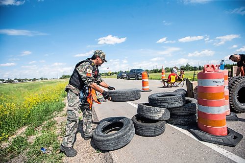 MIKAELA MACKENZIE / WINNIPEG FREE PRESS

Darrell Fontaine rebuilds a blockade closing off Brady Landfill after letting a vehicle through on Thursday, July 6, 2023.  For Chris Kitching story.
Winnipeg Free Press 2023.