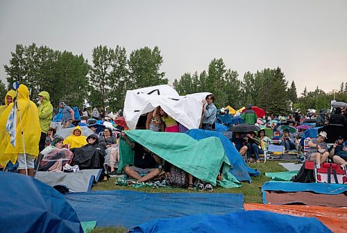 JESSICA LEE / WINNIPEG FREE PRESS

Festival attendees attempt to stay dry July 6, 2023 at Folk Fest during a downpour.

Reporter: Eva Wasney