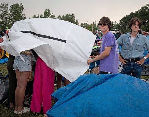 JESSICA LEE / WINNIPEG FREE PRESS

Jack Joseph (in blue) and Scott Kosokowsky attempt to stay dry July 6, 2023 at Folk Fest during a downpour.

Reporter: Eva Wasney