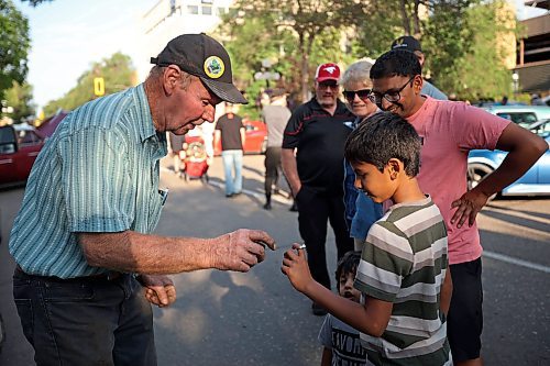 06072023
Farmer and hobbyist blacksmith Barry Bromley makes a horseshoe nail ring for seven-year-old Avi Patel during the Brandon and Area Car Enthusiasts (BACE) Cruise Night in Downtown Brandon on Rosser Avenue on a sunny Thursday evening. Cruise Night takes place on the first Thursday of every month from June through September.
(Tim Smith/The Brandon Sun)