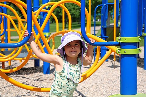 Three-year-old Juno Dunn wears a protective hat while enjoying the playground at Rideau Park in Brandon on Friday. (Michele McDougall/The Brandon Sun)