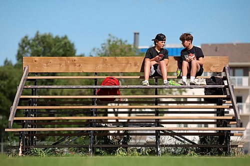 10072023
Twin brothers Kaleb and Gabriel McAuley visit on a set of bleachers while waiting for Vikings football summer camp at Vincent Massey High School in Brandon on a warm Monday afternoon.
(Tim Smith/The Brandon Sun)