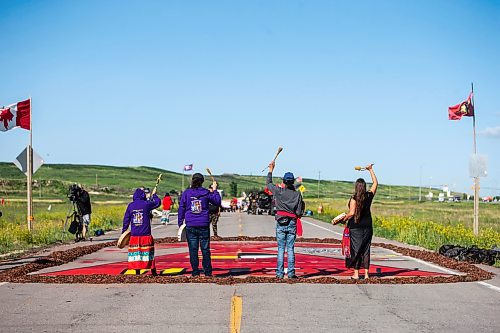 MIKAELA MACKENZIE / WINNIPEG FREE PRESS

Sue Caribou (left), Carl Ullrich, Michael Yellowwing Kannen, and Terri-Lee Bousquet raise their arms at the end of a drum song at the Brady Road blockade on Monday, July 10, 2023.  For Chris Kitching story.
Winnipeg Free Press 2023.