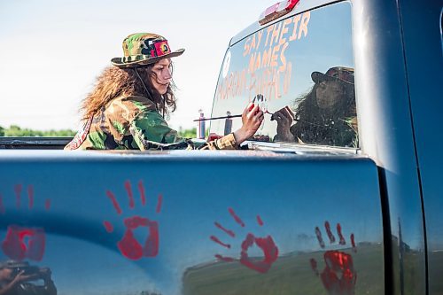 MIKAELA MACKENZIE / WINNIPEG FREE PRESS

Cambria Harris writes the victims names on a truck at the Brady Road blockade on Monday, July 10, 2023.  For Chris Kitching story.
Winnipeg Free Press 2023.