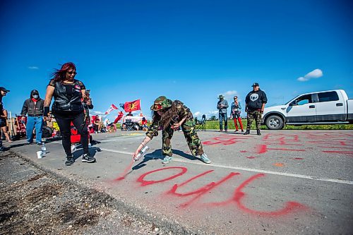 MIKAELA MACKENZIE / WINNIPEG FREE PRESS

Cambria Harris paints her mom&#x573; name onto the asphalt at the Brady Road blockade on Monday, July 10, 2023.  For Chris Kitching story.
Winnipeg Free Press 2023.