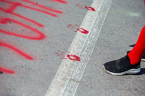 MIKAELA MACKENZIE / WINNIPEG FREE PRESS

Diane Bousquet puts red hand prints down at the Brady Road blockade on Monday, July 10, 2023.  For Chris Kitching story.
Winnipeg Free Press 2023.