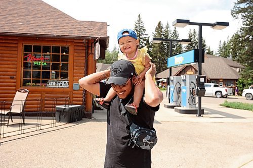 Randy Anderson of Little Saskatchewan First Nation carries his 18-month-old daughter Winter on his shoulders while walking in Wasagaming on Wednesday.  (Tim Smith/The Brandon Sun)