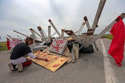 RUTH BONNEVILLE / WINNIPEG FREE PRESS
Local - Brady landfill
Diane Bousquet paints a sign with red paint at blockade Tuesday.
About 10 - 15 people, including some children, remain stationed behind old tires stacked up and filled with lumber on Tuesday afternoon.
This is the 5th day of the blockade along the road to the entrance of of Winnipeg's Brady landfill site which families and supporters want searched for the rremains their murdered loved ones.
July 11th, 2023