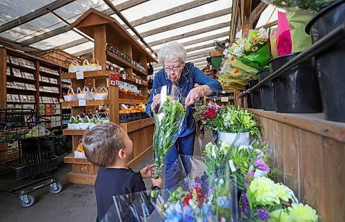 RUTH BONNEVILLE / WINNIPEG FREE PRESS

Standup - Shopping with Great-grandma

Three-year-old Dax Kuffel, checks out various bouquets of flowers with his great-grandmother, Henriette Labossiere, while out with his family on their weekly shopping trip together with his great-grandmother  at St-L&#xe9;on Market Gardens Wednesday.

July 12th,  2023
