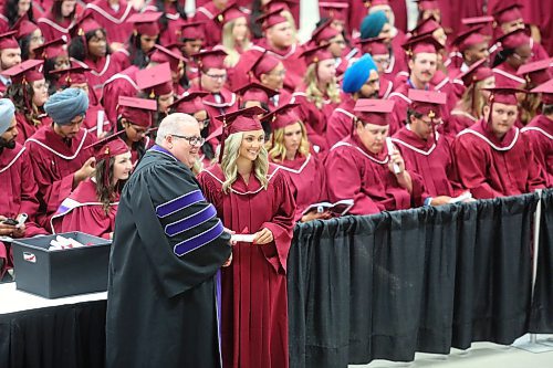 President Mark Frison hands out diplomas to Assiniboine Community College students during Friday's graduation ceremony at the Westoba Place arena in Brandon. (Kyle Darbyson/The Brandon Sun) 