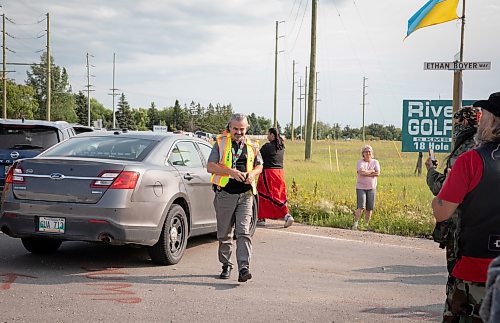 JESSICA LEE / WINNIPEG FREE PRESS

A police liaison walks towards protestors at Brady Landfill July 14, 2023.

Reporter: Chris Kitching