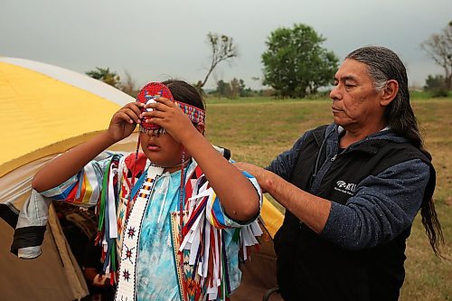 14072023
Carl Taylor, A Dakota Sioux from Portage la Prairie, helps his nephew Patrick Taylor Chaske, 11, get ready for the Grand Entry at the Sioux Valley Dakota Nation Dakota Oyate Wacipi Powwow on Friday evening. Chaske has been dancing for three years and is dancing in the junior boys grass dance this weekend. 
(Tim Smith/The Brandon Sun)