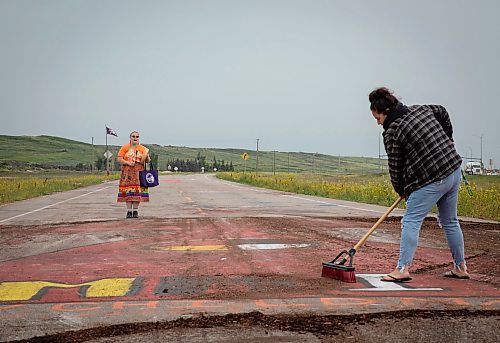 JESSICA LEE / WINNIPEG FREE PRESS
A protestor cleans the mural on the road to Brady Landfill while another protestor sings July 18, 2023 after the removal of the blockade at Brady Landfill earlier that morning.
Reporter: Chris Kitching