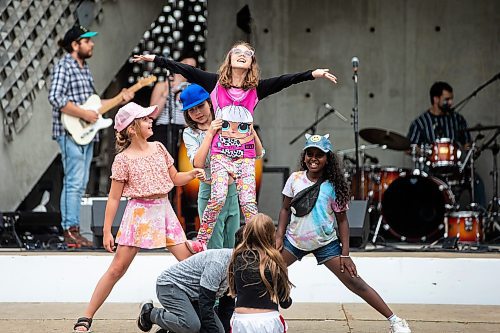 MIKAELA MACKENZIE / WINNIPEG FREE PRESS

Olivia (left, 10), Aubrey (nine), Kaytee (10), and Martha (10), do gymnastic tricks as The Funky Miracles play at Old Market Square at the launch of Fringe Festival on Wednesday, July 19, 2023. Standup.
Winnipeg Free Press 2023.