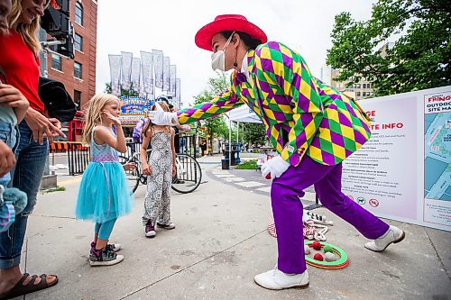 MIKAELA MACKENZIE / WINNIPEG FREE PRESS

T8 the Gr8 (Tait Palsson) wows Lilly (five) and Josephine (six) Fenn with magic tricks and juggling outside of Old Market Square at the launch of Fringe Festival on Wednesday, July 19, 2023. Standup.
Winnipeg Free Press 2023.