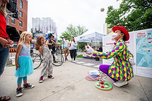 MIKAELA MACKENZIE / WINNIPEG FREE PRESS

T8 the Gr8 (Tait Palsson) wows Lilly (five) and Josephine (six) Fenn with magic tricks and juggling outside of Old Market Square at the launch of Fringe Festival on Wednesday, July 19, 2023. Standup.
Winnipeg Free Press 2023.