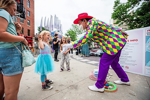 MIKAELA MACKENZIE / WINNIPEG FREE PRESS

T8 the Gr8 (Tait Palsson) wows Lilly (five) and Josephine (six) Fenn with magic tricks and juggling outside of Old Market Square at the launch of Fringe Festival on Wednesday, July 19, 2023. Standup.
Winnipeg Free Press 2023.