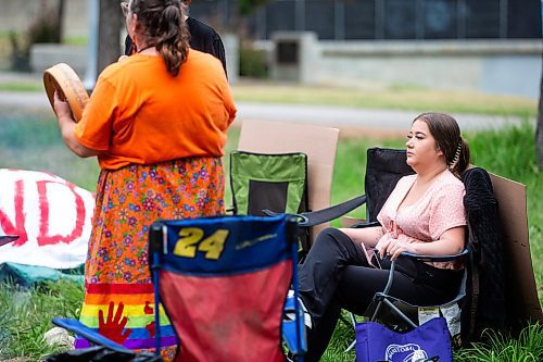 MIKAELA MACKENZIE / WINNIPEG FREE PRESS

Jorden Myran sits as Hummingbird sings a short eagle song at Camp Marcedes (which is by the Canadian Museum for Human Rights) on Wednesday, July 19, 2023. For Chris story.
Winnipeg Free Press 2023.