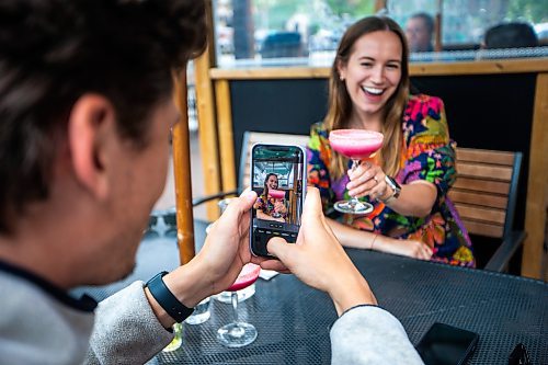 MIKAELA MACKENZIE / WINNIPEG FREE PRESS

Josh Goossen takes a photo of Lily Medynska and her Malibu Barbie cocktail at the Amsterdam Tea House on Wednesday, July 12, 2023.  For AV Kitching story.
Winnipeg Free Press 2023.