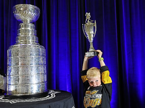 Finn Derlago, 6, holds his 2023 Portage Cup spring tournament trophy while having his photo taken with the Stanley Cup during a public event with the trophy and Vegas Golden Knights general manager Kelly McCrimmon at the Keystone Centre on Friday. McCrimmon had the trophy in Brandon for the whole day, bringing it to a series of public and private events. Thousands lined up throughout the morning to see the cup up close and meet with McCrimmon. See more photos on Page A3, and a story on Page B1. (Tim Smith/The Brandon Sun)