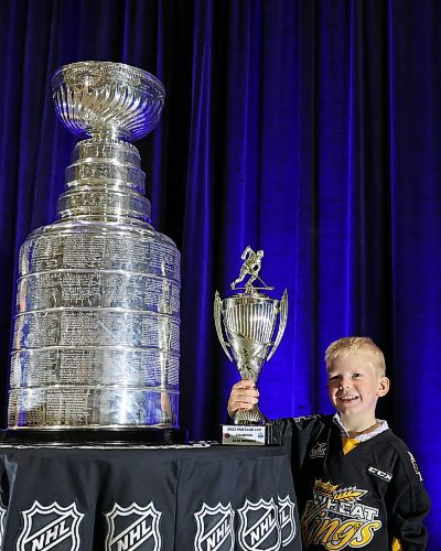 21072023
Six-year-old Finn Derlago holds his 2023 Portage Cup spring tournament trophy while having his photo taken with the Stanley Cup during a public event with the trophy and Vegas Golden Knights general manager Kelly McCrimmon at the Keystone Centre on Friday. McCrimmon had the trophy in Brandon for the whole day, bringing it to a series of public and private events. Thousands lined up throughout the morning to see the cup up close and meet with McCrimmon. (Tim Smith/The Brandon Sun)