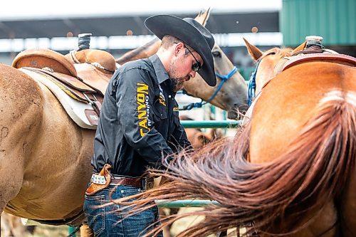 MIKAELA MACKENZIE / WINNIPEG FREE PRESS

Tyler Thomson, pick-up man, gets his horses ready before the start of the rodeo at the Manitoba Stampede in Morris on Saturday, July 22, 2023. For Tyler story.
Winnipeg Free Press 2023